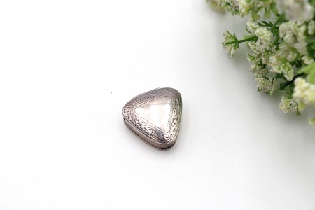 Caixa de comprimidos em prata de forma triangular com friso e gravados na tampa